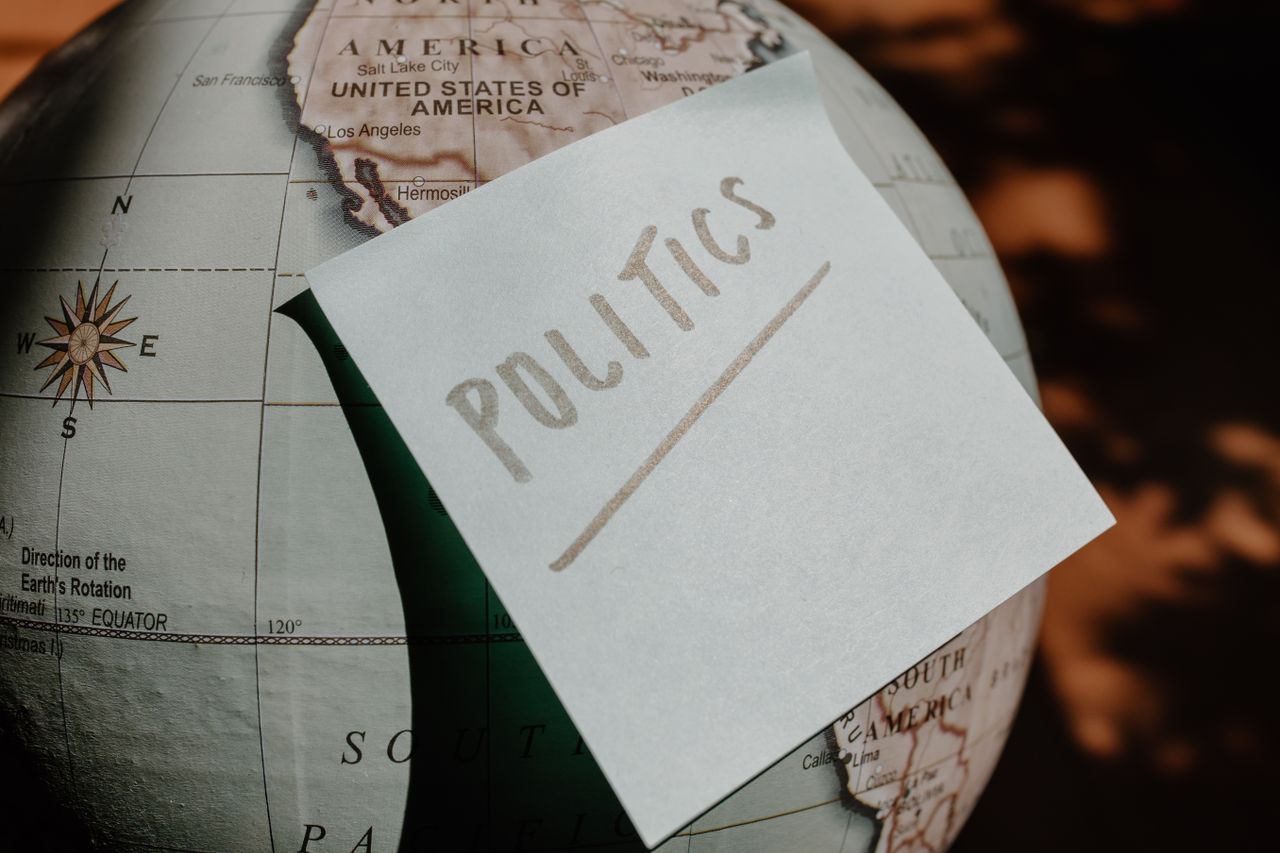 services-01 A close-up of a globe with a politics sticky note, symbolizing global political themes.